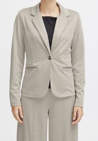 Blazer beige à carreaux avec un revers cranté, une fermeture à un bouton et des poches avant. La texture est lisse avec un motif subtil.