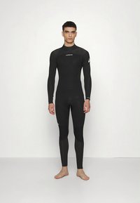 Musta märkäpuku, jossa on pitkät hihat ja lahkeet, valmistettu neopreenistä särmättömällä pinnalla. Rinnassa ja olkapäässä logo.