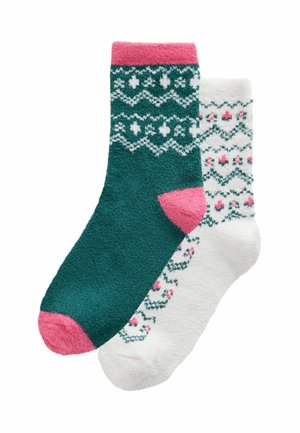 Paar flauschige Socken, eine dunkelgrün mit pinker Ferse und Spitze und weißem gemustertem Bund, die andere weiß mit grünem und pinkem Blumenmuster.