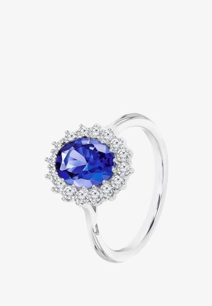 Bague en argent avec une grande pierre précieuse ovale bleue entourée d'un halo de petites pierres claires, avec un anneau lisse et poli.