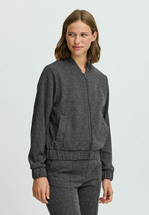 Gray bomber jacket in a soft, textured fabric with a front zipper, ribbed cuffs, and side pockets. Worn with matching gray pants.