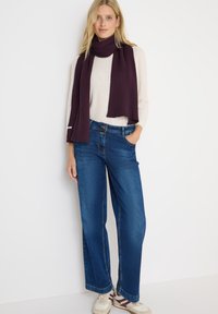 Brede blauwe jeans gecombineerd met een geribde bordeauxrode sjaal en een lichtbeige trui. Gelaagd stof met een casual pasvorm en zakken.