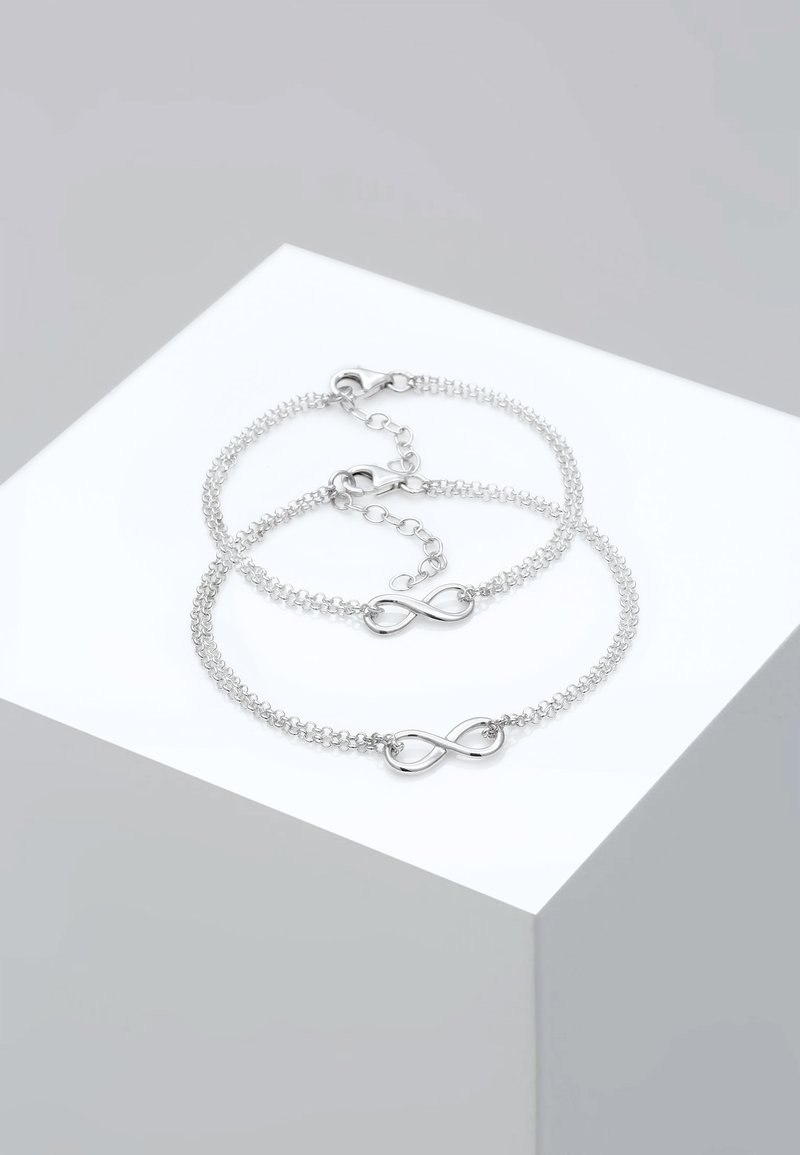 Brățări din lanț cu ton argintiu, având un simbol al infinitului, cu verigi delicate și un design minimal. Unul dintre brățări are o închidere ajustabilă.
