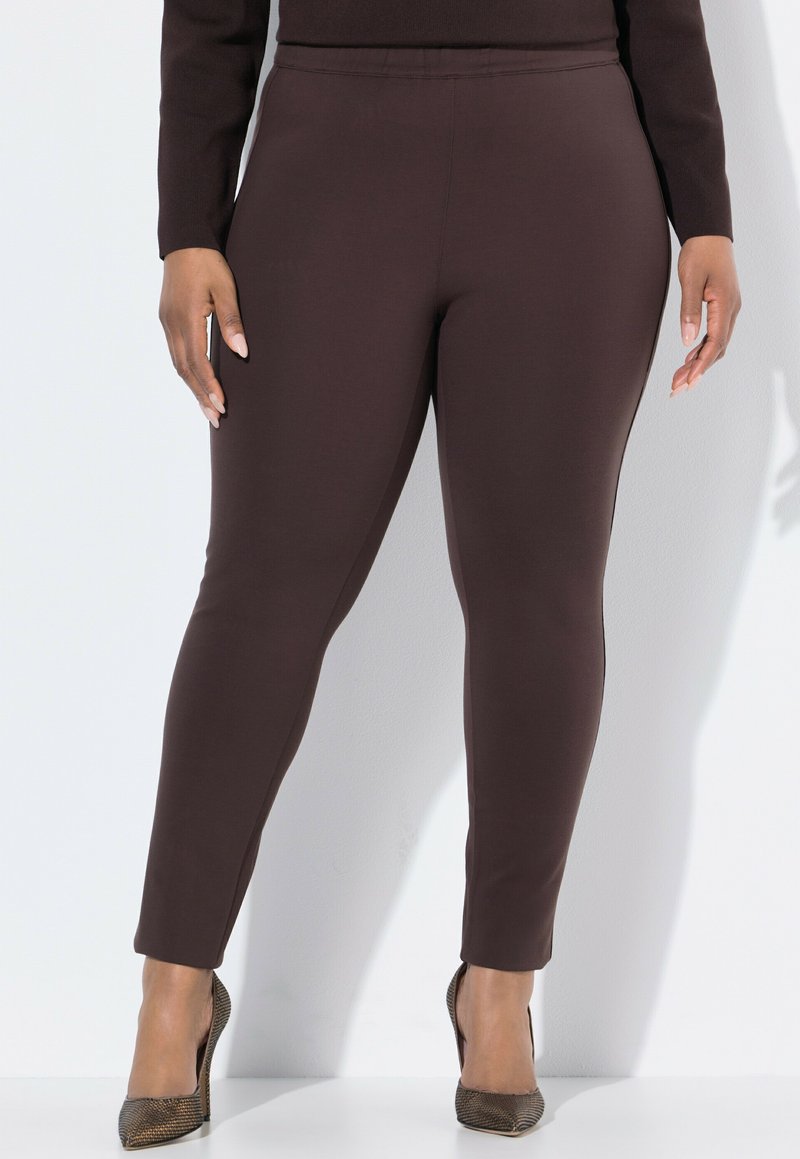 Mörkbruna leggings i ett elastiskt tyg, med en mjuk yta och en avsmalnande passform. Parat med texturerade högklackade skor.