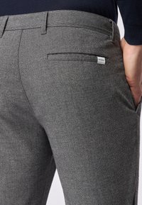 Grijze, textuurgeweven broek met een slim fit, voorzien van een achterzak en een klein merklabel op de tailleband.