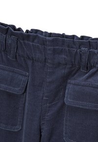 Un pantalon en velours côtelé bleu foncé présente une taille élastique froncée, deux poches avant plaquées et une texture à côtes verticales pour plus de détails.