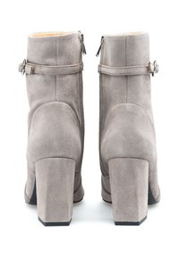 Grijze suede enkellaarzen met een blokhak, voorzien van achterste ritsen en een decoratieve band met een metalen gesp. Gladde textuur, minimalistisch ontwerp.