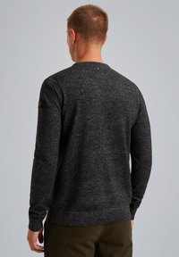 Dunkelgrauer Pullover mit strukturiertem Strickdesign, Rundhalsausschnitt und langen Ärmeln. Verfügt über ein dezentes Logo-Patch auf der linken Schulter.