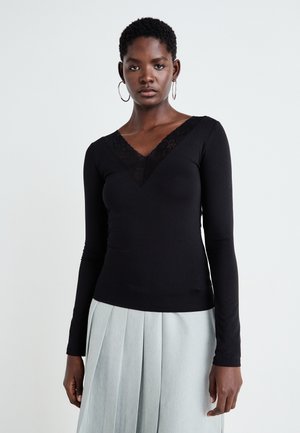 Black long-sleeve top made of soft fabric, featuring a V-neckline with lace trim. The fit is snug against the body.