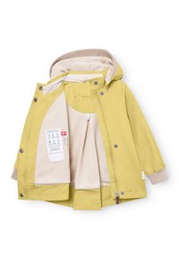 Rumena otroška jopa z rdečo kapuco, notranjim bež flisom, zadrgo spredaj, pritiskači in oznakami za nego tkanin znotraj.