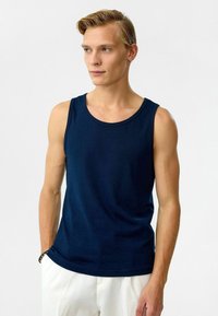 Marineblauwe katoenen tanktop met een ronde halslijn, mouwloos ontwerp en een gladde textuur. Eenvoudige en klassieke silhouet.