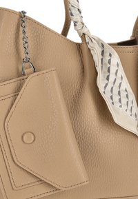 Beige tekstureret læderhåndtaske med en aftagelig pung, sølvfarvet kæde, og et mønstret stoftørklæde bundet om håndtaget.