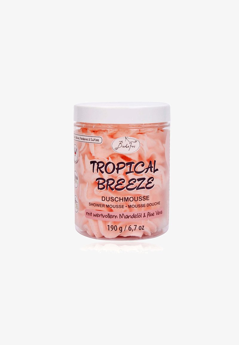 Pink shower mousse in a clear jar with white lid. Label features "TROPICAL BREEZE," product details, and ingredient highlights. 190g.