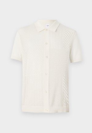 Lühikeste varrukatega, kreemikollane kootud polo särk, millel on tekstureeritud, mustriline disain, nööpkinnitused ja klassikaline krae.