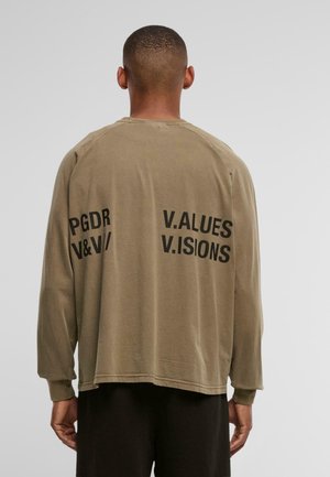 Ilgo rankovėmis alyvuogių spalvos marškiniai, pagaminti iš minkštos medžiagos, su dideliu juodu tekstu ant nugaros: "PGDR V&V/V.ALUES V.ISIONS."