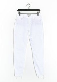 Vaqueros de denim blanco con un ajuste skinny, que presentan detalles desgastados y dobladillos deshilachados. Diseño de cinco bolsillos con acentos de herrajes metálicos.