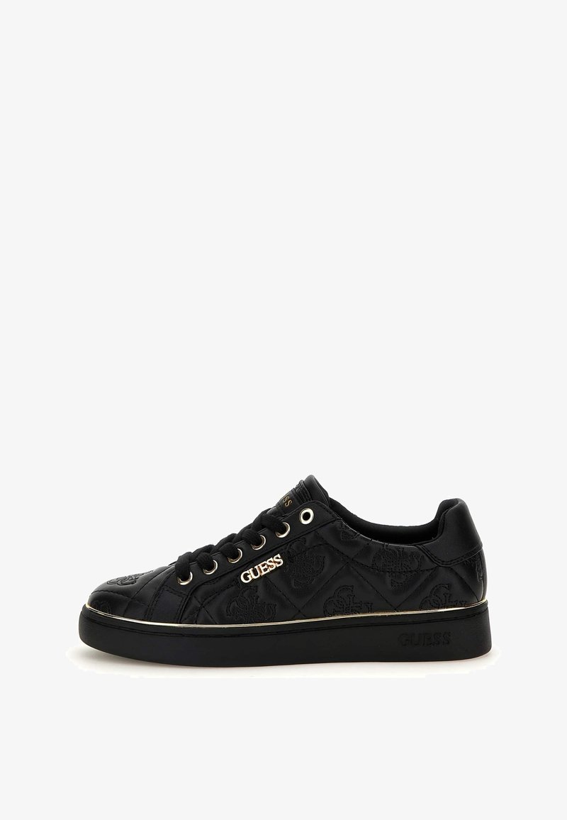 Baskets basses noires avec motif matelassé, logo doré "GUESS" sur le côté, lacets noirs et semelle noire épaisse avec un liseré doré discret.