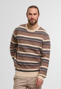 Maglione a righe con design a girocollo, realizzato in tessuto testurizzato nei colori beige, marrone e blu navy con polsini e orlo a coste.