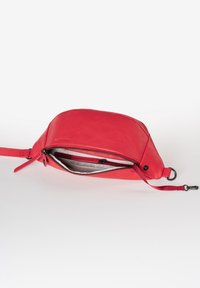 Borsa in pelle rossa con forma triangolare, chiusura a zip e tracolla staccabile. Presenta una texture liscia e una fodera interna morbida.