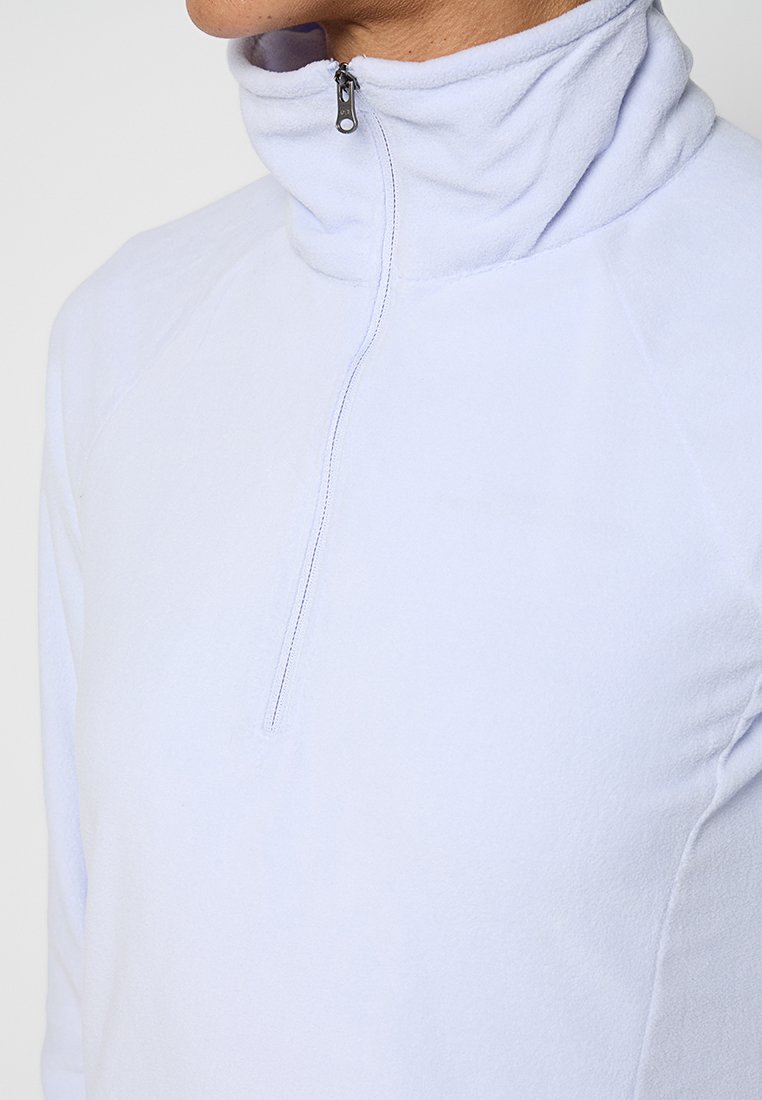 Sudadera de forro polar de color azul claro con cuello alto, que presenta un cierre de media cremallera en la parte delantera y una textura suave. Costuras visibles en los hombros.