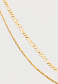 Guldsmykker med tre kæder: en flad oval lenke kæde, en slank slange kæde og en tekstureret, rund kæde, alle med en glat finish.