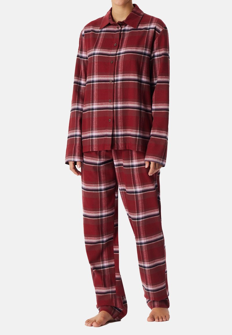 Rood en een ruitachtig pyjamastel gemaakt van zachte stof, met een knoopsluiting boven, losse broekspijpen, lange mouwen en een kraag.