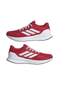 Red athletic shoes with a breathable mesh upper, white three-stripe design, white midsole, and rubber outsole with textured grip.