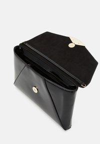 Mustikkanahtopinnan clutch-laukku, jossa on geometrinen kuvio, kultaisia ympyrän muotoisia koristeita ja keinonahkainen sisus. Aukeaa näyttämään sisäosan.
