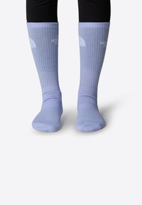 Medias de color púrpura claro hasta la rodilla con textura acanalada y detalle de logo. Tejido suave con secciones de puntera y talón reforzadas.