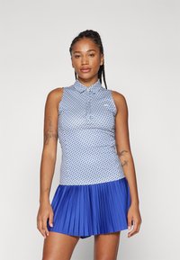 Blue and white sleeveless polo dress with a collared neck, patterned bodice, and a pleated blue skirt. Smooth fabric, sport design.