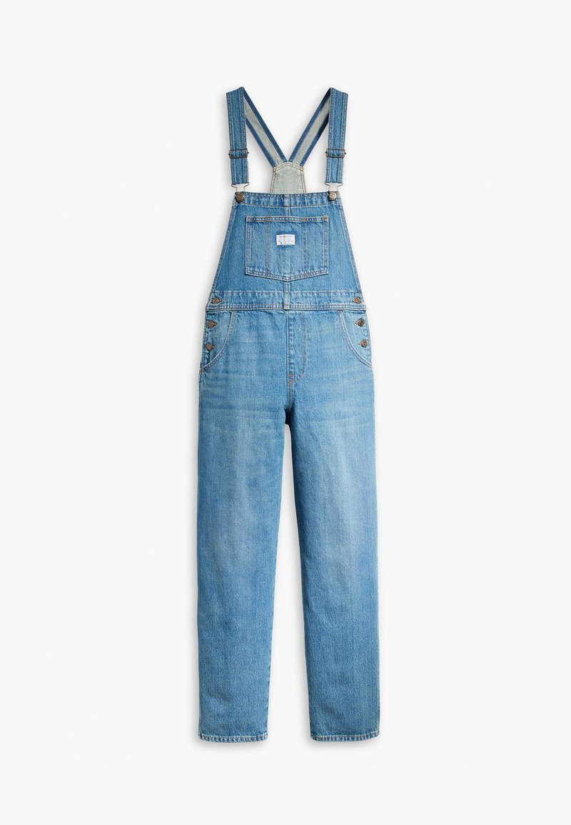 Salopette en jean bleu clair avec bretelles ajustables, poche avant et fermetures métalliques. Pantalons droits avec une texture délavée sur le tissu.