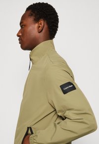 Calvin Klein CRINKLE BLOUSON - Lichte jas - delta green