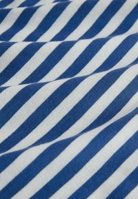 Medvilninis audinys, kuriame kaitaliojasi mėlynos ir baltos horizontalios juostos, turi minkštą tekstūrą ir nesiglamžančią išvaizdą.