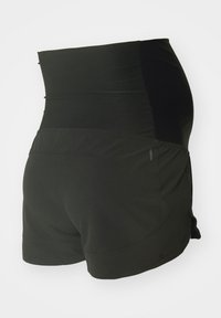 Pantalones cortos deportivos negros con cintura alta. Fabricados en tejido elástico, con una textura suave y sutiles bolsillos laterales. Se muestra la vista trasera.