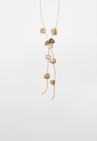 Collana lunga in oro con molteplici charm a forma di foglia, di diverse dimensioni, con una catena intrecciata e dettagli delicati.