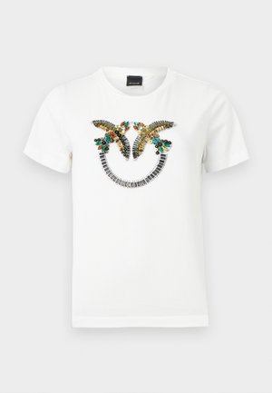 Λευκό t-shirt με κοντά μανίκια με δύο διακοσμητικά πουλιά που κοιτάζουν το ένα το άλλο πάνω από μια ημικυκλική διακόσμηση από μεταλλικές και πολύχρωμες χάντρες.