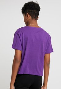 Kort lila bomull t-shirt med korta ärmar, en lös passform och rund halsringning, med en ren fåll och utan synliga mönster eller grafik.