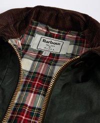Casaco verde escuro com gola de bombazina castanha, forrado com padrão tartan vermelho e verde e fecho dourado. Etiqueta Barbour visível no interior.