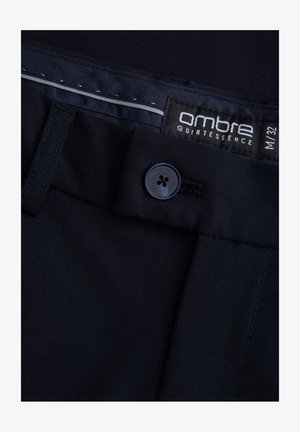 Tmavě modré kalhoty z hladké tkaniny, vybavené zapínáním na knoflík, štítkem s logem "ambre" a jemným šitím.