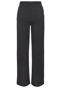 Melni, plata kāja bikses, izgatavotas no mīksta auduma. Tām ir elastīga josta un nav redzamu kabatu vai rotājumu. Gluda tekstūra.