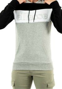 Sudadera con capucha gris con mangas negras y panel blanco en el pecho; cuenta con capucha con cordón y bolsillos delanteros; logo "ellesse" en gris claro en el pecho.