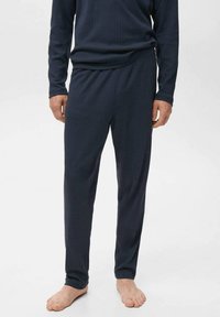 Marineblaues, geripptes Loungewear-Set mit langen Ärmeln und Hose, aus weichem Stoff, mit einer lockeren Passform und ohne sichtbares Branding.