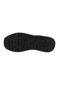 Silueta de zapatilla negra con una suela de goma texturizada que presenta patrones de relieve profundos y agarres circulares para tracción y durabilidad.