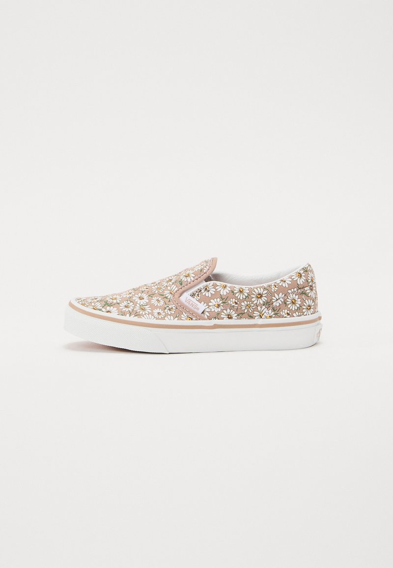 Chaussure slip-on en toile avec un motif floral marron présentant des marguerites blanches et des accents verts. Semelle en caoutchouc blanche avec un contour beige clair.
