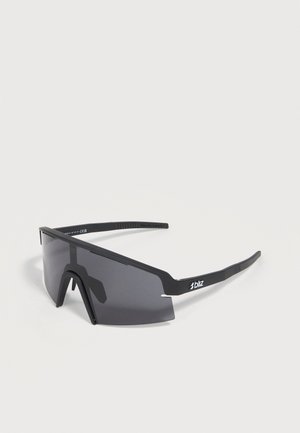 Lunettes de soleil de sport noires enveloppantes avec des verres teintés foncés et le logo « bliz » sur la branche, présentées sur un fond clair uni.