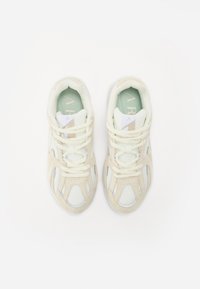 Beige mesh en suède sneakers met witte accenten, ronde neus, gevoerde tong en vetersluiting. Zachte textuur, minimalistisch ontwerp.