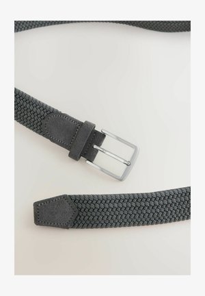 Sötétszürke szövött szövet öv nubuk béléssel és ezüst fém csattal, laposan elhelyezve egy világos felületen.