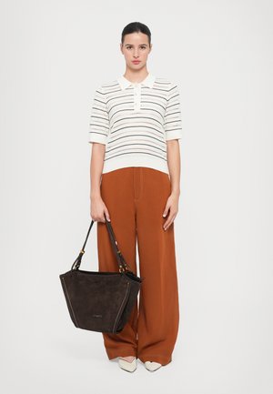 Brown suede tote bag with gold accents, wide opening, and dual handles. Pairing with a white striped knit polo and brown wide-leg pants.