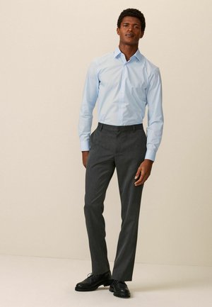 Light blue button-up shirt paired with gray tailored trousers and black leather shoes. Features slim fit and classic design.