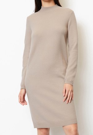 Abito a maniche lunghe con collo alto in maglia beige chiaro. Taglio dritto, lunghezza a metà coscia, con dettagli a costine su polsini e orlo.